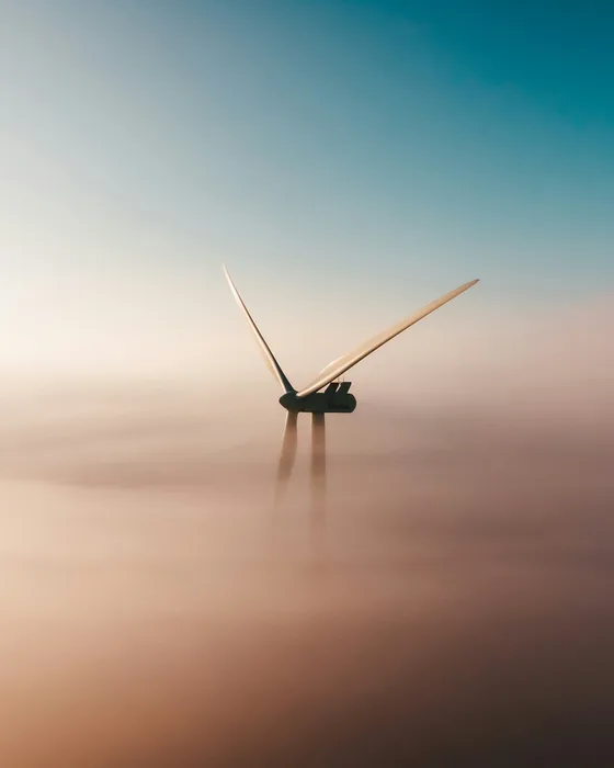 Éolienne émergeant d'une mer de nuages
