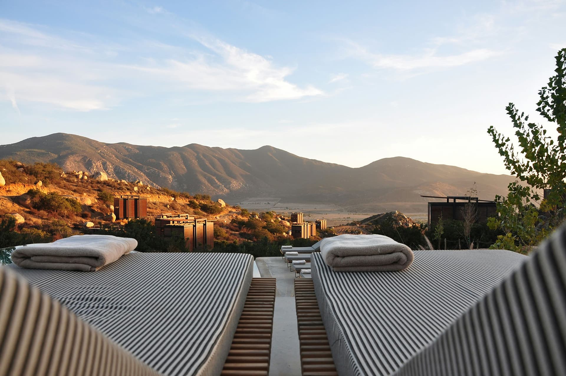 Terrasse d'un hôtel ouverte sur une vallée au coucher du soleil